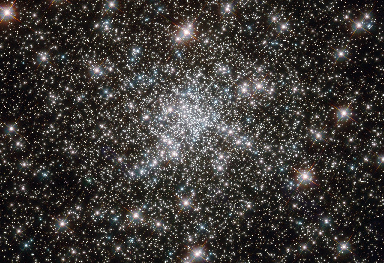 Hubble-Aufnahme des Kugelsternhaufens NGC 6752 mit tausenden dicht stehenden Sternen vor schwarzem Hintergrund.