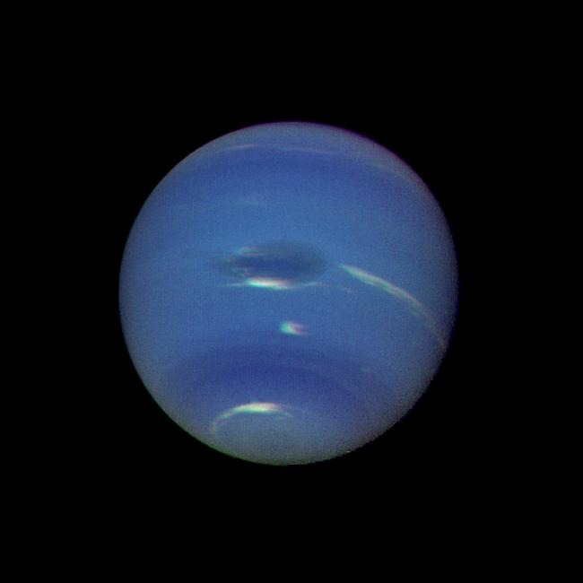 Der Planet Neptun in blaugrüner Farbe mit dem Großen Dunklen Fleck, aufgenommen von der Raumsonde Voyager 2.